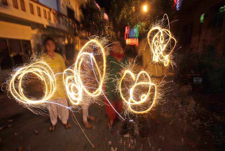 People handle fireworks to celebrate Diwali, the Hindu festival of lights, in Jammu India, Sunday, Nov. 3, 2013. Hindus across the country are celebrating Diwali where people decorate their homes with lights, let off fireworks and pray to Lakshmi, the goddess of wealth. (Photo credit: AP Photo)