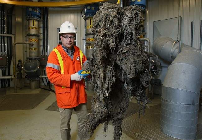 Barry Orr of the City of London Environmental and Engineering Services lifts a giant mass of material, primarily wipes that are supposed to be flushable, that had been clogging the sewage system pumps in London, ON, Friday, Nov. 15, 2013.