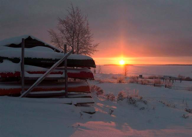 Canoes are stacked for the winter as the sun rises Tuesday, December 18, 2012, on the Fort Hope First Nation, Ont.