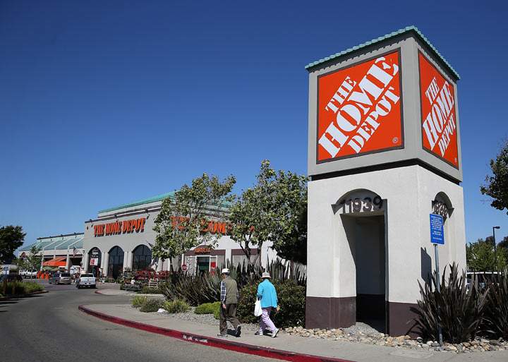 People walk by a sign in front of a Home Depot store on May 21, 2013 in El Cerrito, California. 