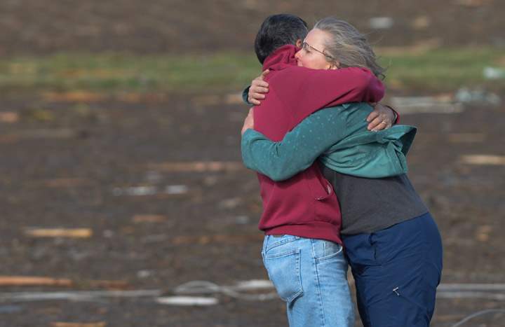Residents embrace after they discovered their home was destroyed when a tornado and thunderstorms tore through a portion of Washington, Ill., on Sunday, Nov.17, 2013. (Photo credit: AP Photo)