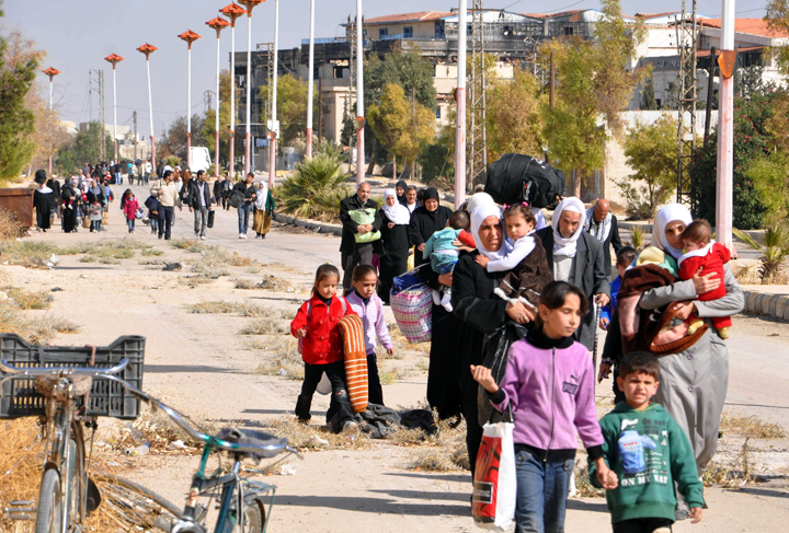 Syrian civilians evacuate the war-battered suburb of Damascus, Moadamiyet al-Sham, with the help of the Social Affairs Ministry, as fighting between pro-government troops and rebel fighters continues in districts of the capital, on October 29, 2013.