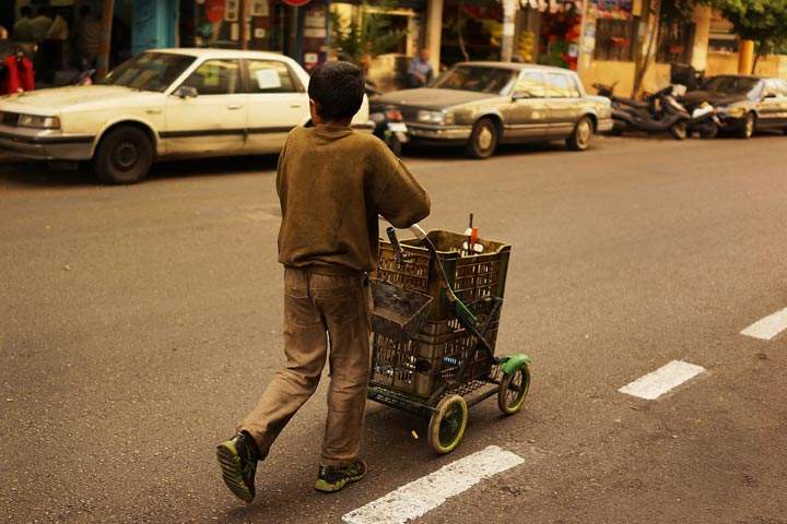 Syrian boy collects metal scrap to sell in a wealthy district of Beirut on November 16, 2013 in Lebanon. 
