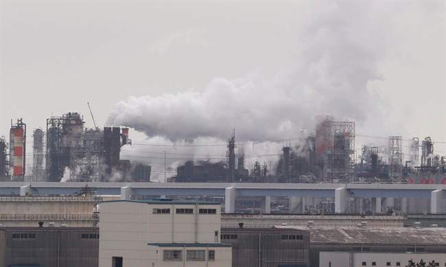 In this Monday, Oct. 21, 2013 photo, smoke billows from an oil refinery in Kawasaki, southwest of Tokyo. 