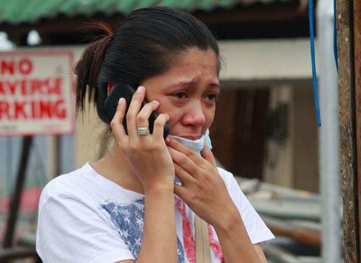 A woman cries as she talks on the phone to her relatives in the aftermath of Typhoon Haiyan on November 12, 2013 in Tacloban, Leyte, Philippines. Typhoon Haiyan, packing maximum sustained winds of 195 mph (315 kph), slammed into the southern Philippines and left a trail of destruction in multiple provinces, forcing hundreds of thousands to evacuate and making travel by air and land to hard-hit provinces difficult. (Photo credit: Getty Images)