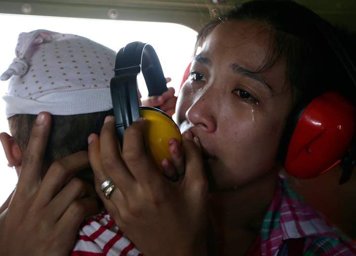 A mother cries in relief upon boarding a Philippine Air Force helicopter, on Nov. 11, 2013 following Friday’s typhoon Haiyan which lashed Guiuan township, Eastern Samar province, central Philippines. (Photo credit: AP Photo)