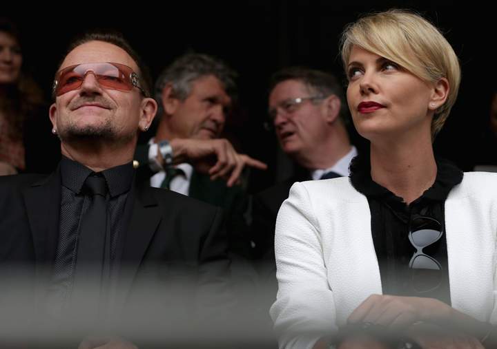 Singer Bono and South African actor Charlize Theron arrive for the official memorial service for former South African President Nelson Mandela at FNB Stadium Dec. 10, 2013 in Johannesburg, South Africa. (Photo credit: Getty Images)