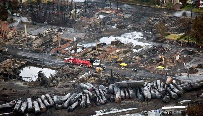 Workers comb through debris days after an unmanned train with 72 railway cars carrying crude oil derailed July 6, causing explosions in Lac-Megantic, Que. CANADIAN PRESS/Paul Chiasson
