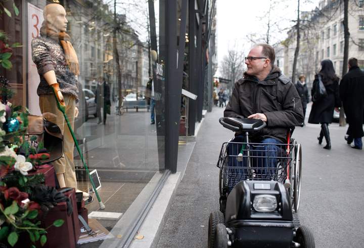 A passerby looks at a mannequins modeled after people with disabilities are displayed in store windows. (Photo credit: Alexandra Wey/Photopress)