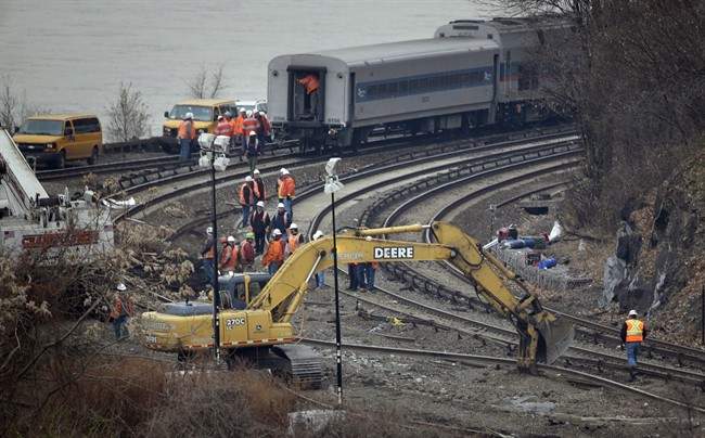 A construction machine moves a section of railroad track near the site of a train derailment in the Bronx section of New York, Monday, Dec. 2, 2013. THE CANADIAN PRESS/AP, Seth Wenig