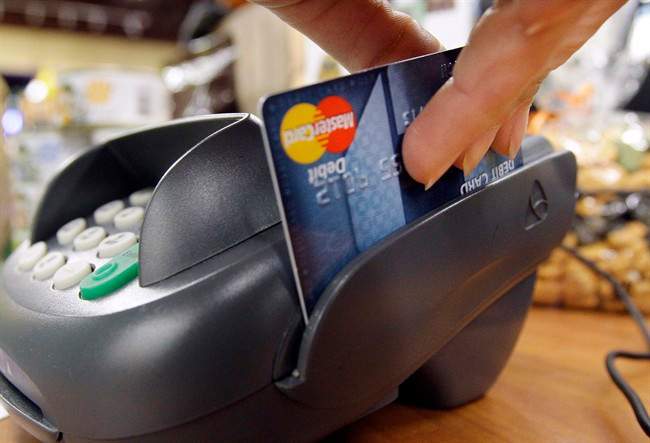 In this Nov. 2, 2009 photo, a customer swipes a debit card through a point-of-sale machine.