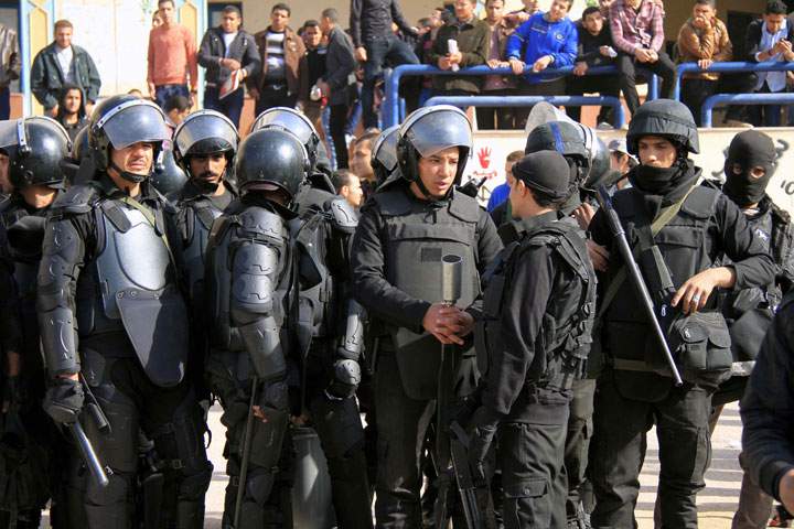 Al-Azhar University students who support the Muslim Brotherhood and deposed President Mohamed Mursi, shout slogans in front of riot police on Dec. 29, 2013.