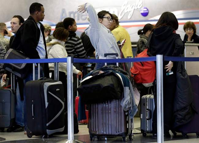 Passengers line up at ticket counters inside Terminal 3 at O'Hare International Airport in Chicago on Friday, Dec. 20, 2013. A local weather forecast predicts rain will continue Friday with some light freezing drizzle, with a chance of rain and sleet Saturday morning, turning to snow and sleet in the afternoon. 