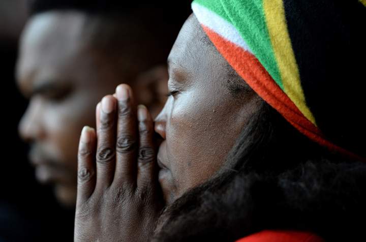 A woman prays during the Nelson Mandela memorial service at the FNB Stadium, on Dec. 10, 2013 in Johannesburg, South Africa. (Photo credit: Getty Images)