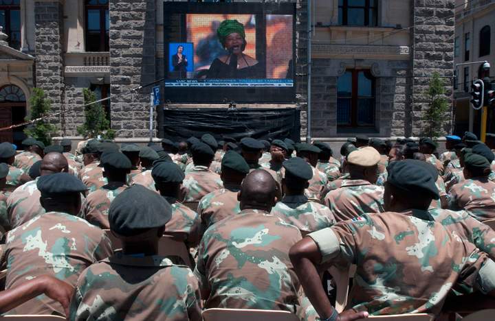 Members of the South African National Defence Force watch the official memorial service for Mandela on big screens in the city centre of Cape Town on Dec. 10, 2013. (Photo credit: Getty Images)