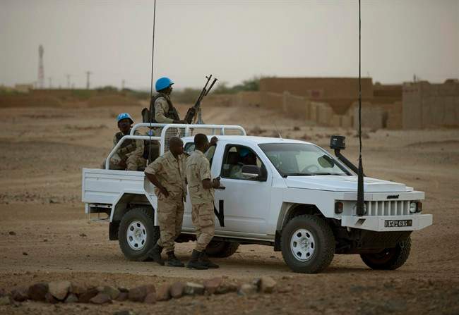 In this July 28, 2013 photo, United Nations peacekeepers stand guard at a polling station, during presidential elections in Kidal, Mali. 