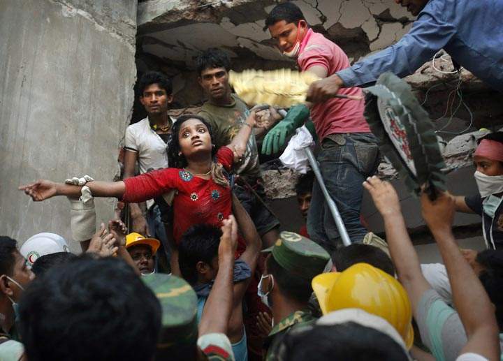 A survivor is lifted out of the rubble by rescuers at the site of a building that collapsed in Savar, near Dhaka, Bangladesh. (AP Photo/Kevin Frayer)