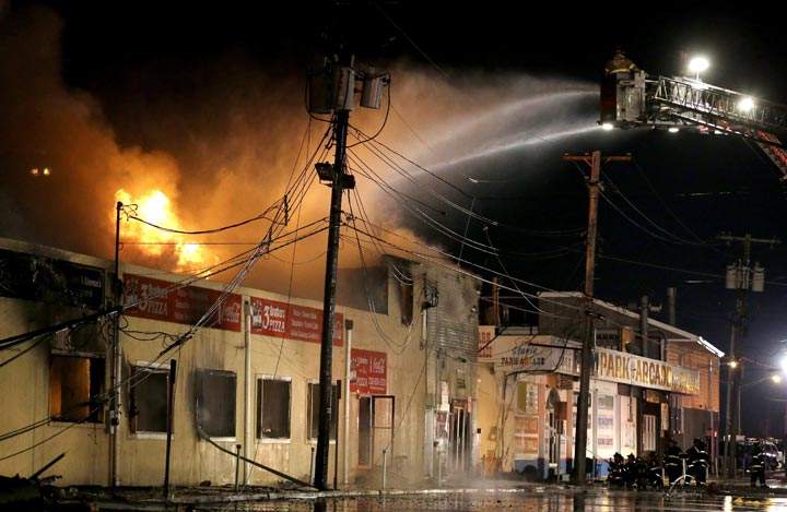 Firefighters battle a blaze in a building on the Seaside Park boardwalk in Seaside Park, N.J. (AP Photo/Julio Cortez)