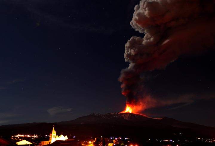 Mt. Etna, Europe’s most active volcano, spews lava as smoke billows during an eruption as seen near the Sicilian town of Catania, Italy. (AP Photo/Carmelo Imbesi)