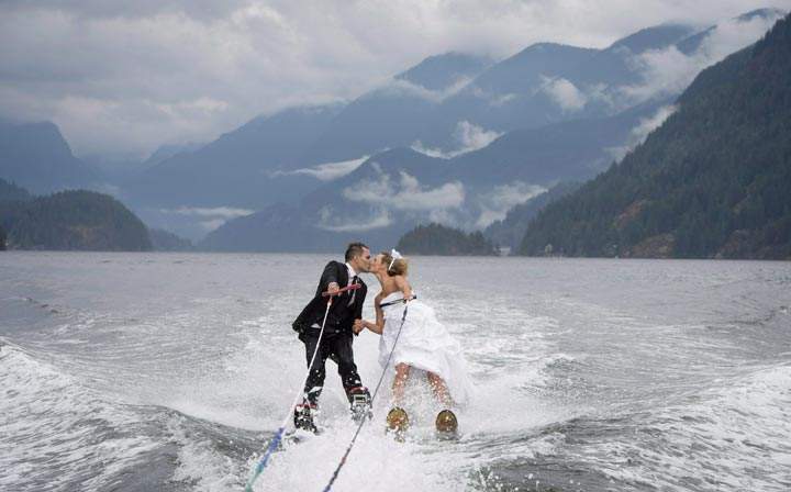 Newlyweds Cam Auge and Caylee Wasilenko share a kiss as they water ski in Bedwell Bay in North Vancouver, B.C. (The Canadian Press /Jonathan Hayward)