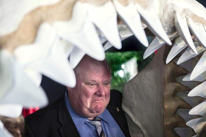 Toronto Mayor Rob Ford poses for a photo opportunity with other dignitaries in a shark’s jaw at the opening of Ripley’s Aquarium of Canada in Toronto. (The Canadian Press /Chris Young)
