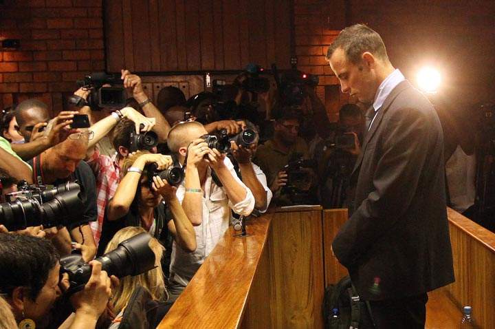 Photographers take photos of Olympic athlete Oscar Pistorius as he stands during his bail hearing at the magistrates court in Pretoria, South Africa. This was Pistorius’ bail hearing over the shooting death of his girlfriend. (AP Photo/Themba Hadebe)