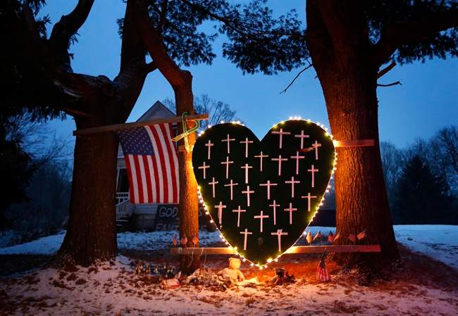  In this Saturday, Dec. 14, 2013, file photo, a makeshift memorial with crosses for the victims of the Sandy Hook massacre stands outside a home in Newtown, Conn., the one-year anniversary of the shootings. 