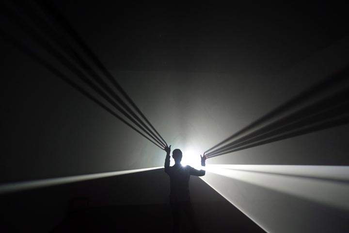A Hayward Gallery employee poses for photographers inside artist Anthony McCall’s installation at a gallery in London. (AP Photo/Lefteris Pitarakis)