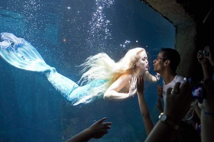 Visitors watch a mermaid as she swims in a giant tank at an aquarium in Sao Paulo, Brazil. (Nelson Almeida/AFP/Getty Images)
