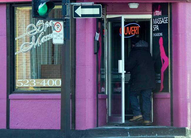 A man enters a massage parlour in Montreal. In 2012, the government stopped issuing temporary foreign worker permits to sex industry workers in an effort to crack down on human trafficking.