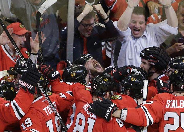 Chicago Blackhawks defenseman Brent Seabrook, centre, celebrates with his teammates after scoring during overtime in Game 7 of the NHL hockey Stanley Cup Western Conference semi-finals against the Detroit Red Wings on Wednesday, May 29, 2013, in Chicago. (AP Photo/Nam Y. Huh)