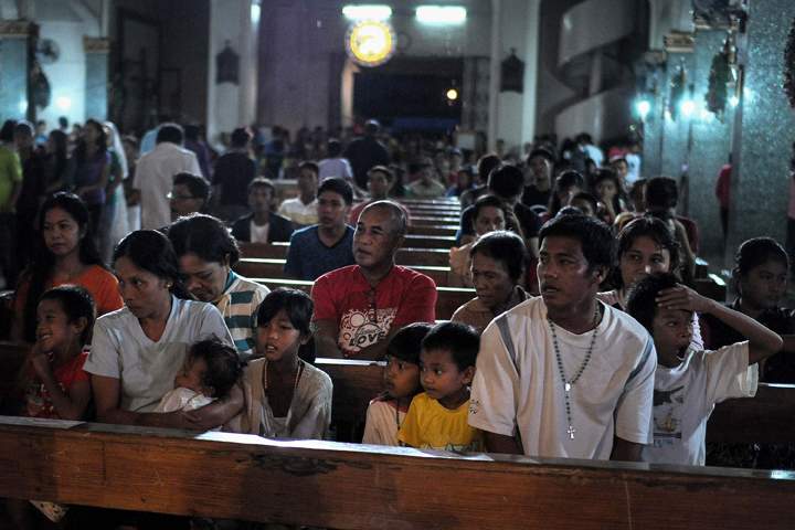 Typhoon survivors attend the final dawn mass on Christmas eve at a church in typhoon-hit Tacloban, Philippines, December 24, 2013. (Photo credit: AP Photo)