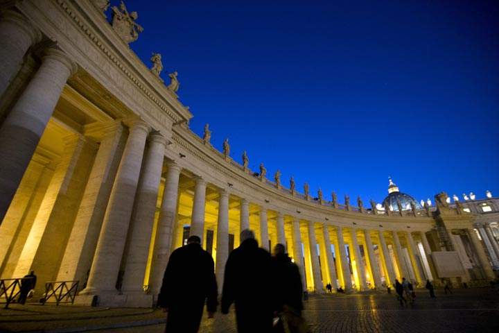 The sun sets behind the colonnade of St' Peter's Square at the Vatican, Tuesday, Dec. 17, 2013.