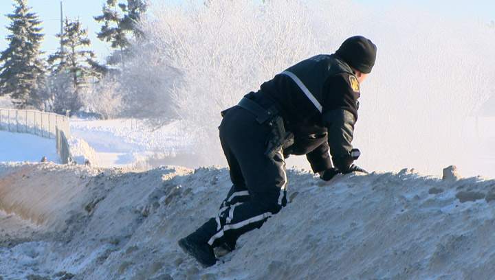 A police officer looks over the Circle Drive North Bridge where a vehicle went into the South Saskatchewan River Monday afternoon.