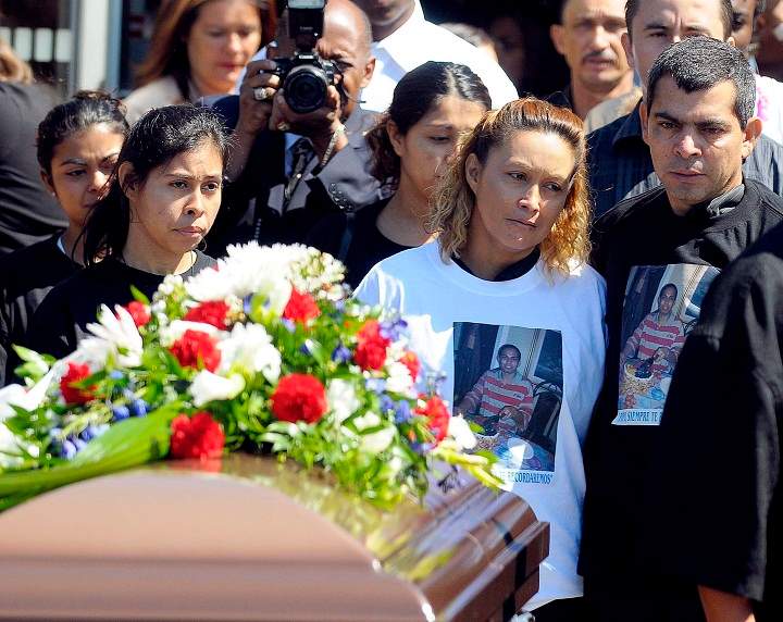 Gilberto and Lilian Villanueva (right) the parents of Fredy Villanueva, and other family members pass by the coffin at his funeral in Montreal, Thursday August 14, 2008.