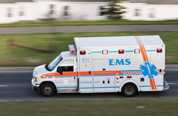 An ambulance speeds along Calgary's 14th Street NW in response to an emergency call.