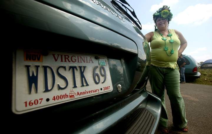Skyfeather stands next to her custom licence plate near where the concert marking the 40th anniversary of the Woodstock music festival will be held.