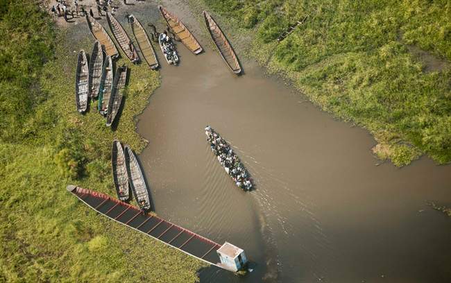 In this Monday, Dec. 30, 2013 file photo, a boat packed with passengers arrives at a dock after crossing a waterway near the town of Malakal, the capital of Upper Nile State.