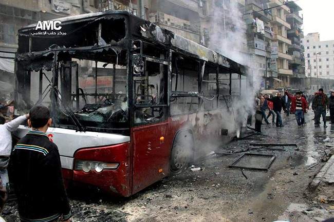 This citizen journalism image provided by Aleppo Media Center AMC which has been authenticated based on its contents and other AP reporting, shows Syrians inspecting a burnt bus after a missile fired by Syrian government aircraft hit the vehicle in the rebel-held neighborhood of al-Bab in Aleppo, Syria, Tuesday, Dec. 31, 2013. 
