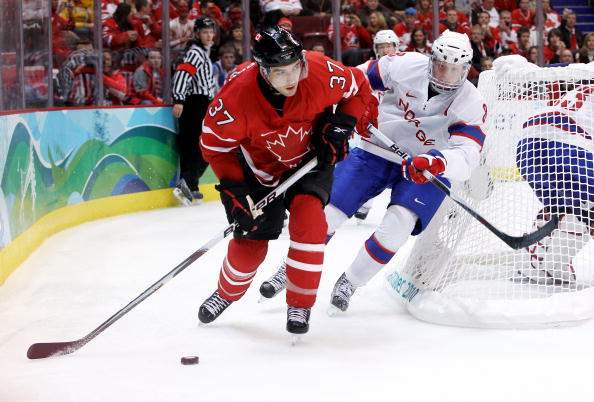 Patrice Bergeron of Canada skates with the puck against Mads Hansen of Norway during the ice hockey men's preliminary game between Canada and Norway on day 5 of the Vancouver 2010 Winter Olympics at Canada Hockey Place on February 16, 2010 in Vancouver.