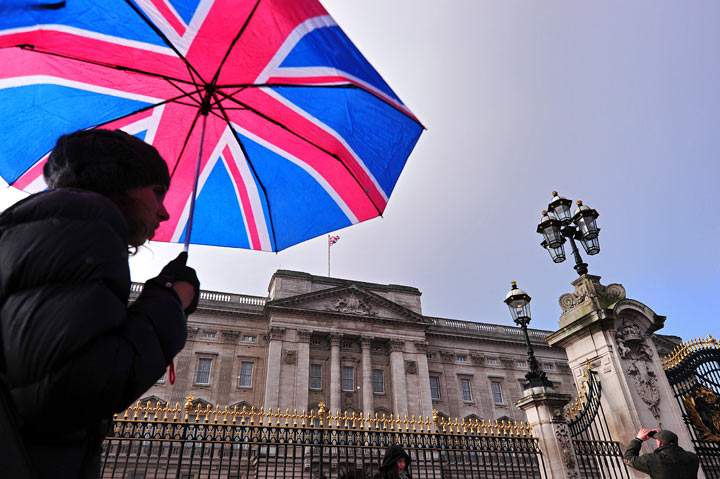 A tourist walks past Buckingham Palace in central London, on January 28, 2014. (Photo by CARL COURT/AFP/Getty Images)