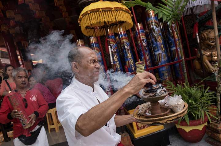 A Balinese ethnic Chinese man prepares offerings during the ‘Ngelawang’ Ritual at Dharmayana Chinese Temple on Jan. 30, 2014 in Kuta, Indonesia.(Photo credit: Agung Parameswara/Getty Images)