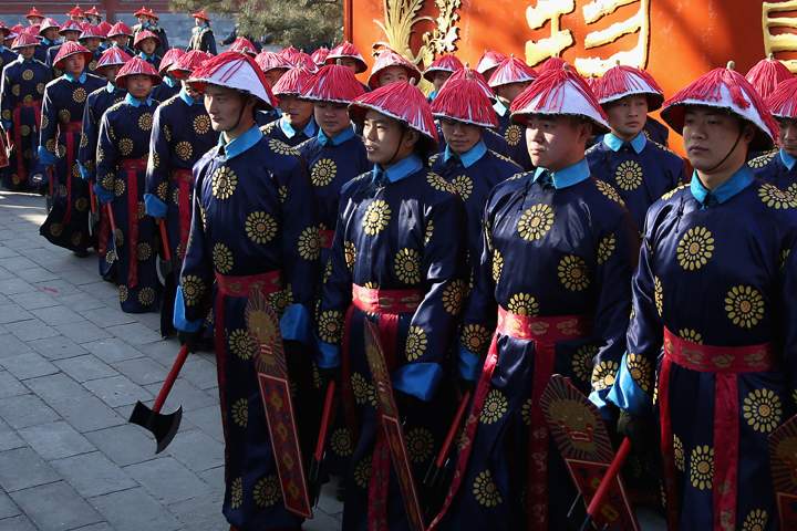 Chinese paramilitary police officers dressed as Qing Dynasty servants before a re-enactment of an ancient ceremony of Qing Dynasty emperors praying for good harvest and fortune during the opening ceremony of the Spring Festival Temple Fair at the Temple of Earth park on Jan. 30, 2014 in Beijing, China. (Photo credit: Feng Li/Getty Images)