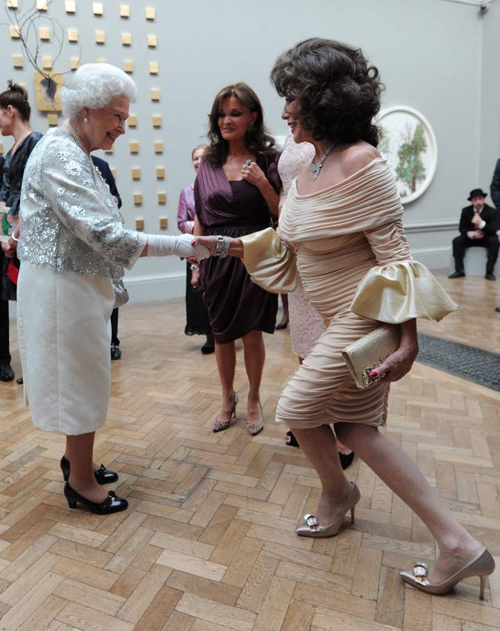 Queen Elizabeth II meets a curtseying Joan Collins at a special ‘Celebration of the Arts’ event at the Royal Academy of Arts on May 23, 2012 in London, England.