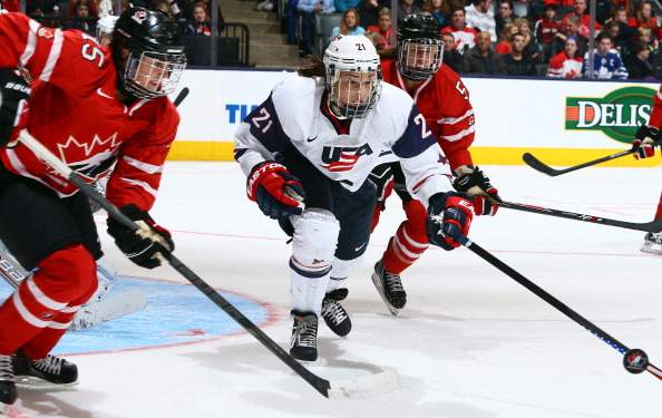 Melodie Daoust #15 of Team Canada chases the puck against Hilary Knight #21 of Team USA during a Sochi Olympics preparation game at the Air Canada Centre December 30, 2013 in Toronto.
