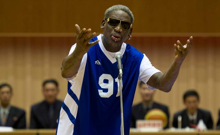 Dennis Rodman sings Happy Birthday to North Korean leader Kim Jong Un, seated above in the stands, before an exhibition basketball game at an indoor stadium in Pyongyang, North Korea on Wednesday, Jan. 8, 2014. (Photo credit: AP Photo/Kim Kwang Hyon)