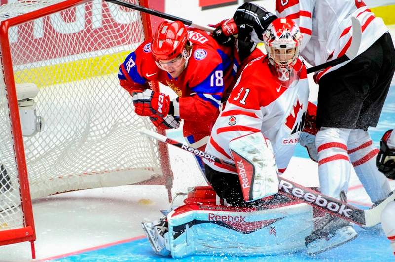 Russia's Vyacheslav Osnovin, left, is checked into the net behind Canada's goalie Zachary Fucale during the World Junior Hockey Championships bronze match between Canada and Russia at Malmo Arena in Malmo, Sweden, Sunday, Jan. 5, 2014. (AP Photo/Ludvig Thunman, TT News Agency).