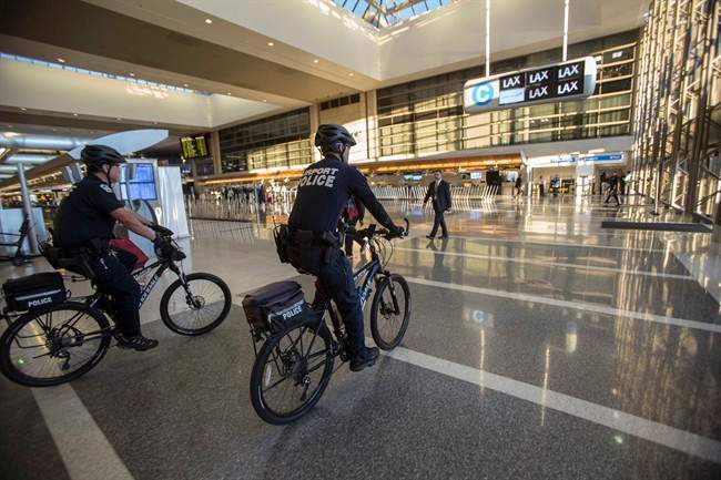 FILE - In this Nov. 2, 2013 file photo, airport police officers patrol the Tom Bradley International Terminal at the Los Angeles International Airport. 