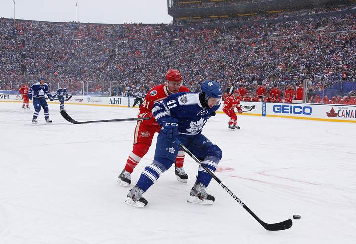 Nikolai Kulemin #41 of the Toronto Maple Leafs fights off Luke Glendening #41 of the Detroit Red Wings during the 2014 Bridgestone NHL Winter Classic at Michigan Stadium on January 1, 2014