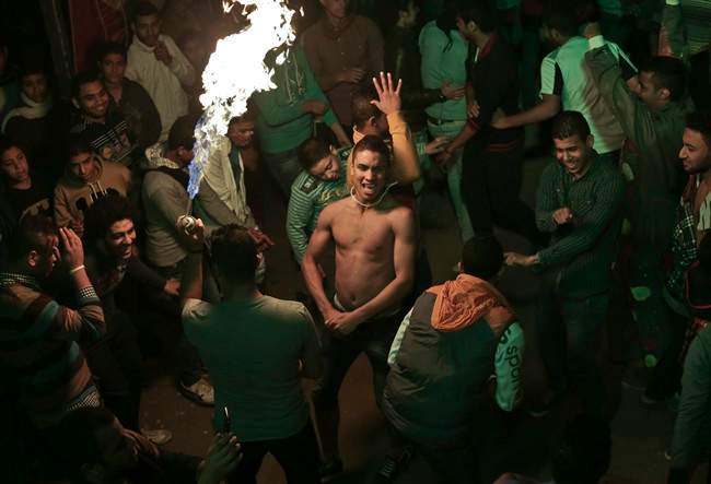 In this Thursday, Dec. 19, 2013 photo, Egyptian youths dance, to music during a bachelors party, in El-Marg, a suburb northeast of Cairo, Egypt. 
